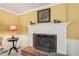 Comfortable living room featuring a fireplace, yellow walls, white molding and a charming side table at 7109 River Birch Dr, Raleigh, NC 27613