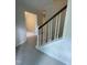 View of the carpeted staircase with white wood trim and dark wood handrail in a home with neutral colored walls at 7109 River Birch Dr, Raleigh, NC 27613