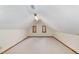 This attic space features neutral carpet, trim detail, and two windows at 7212 Rabbit Run, Wake Forest, NC 27587