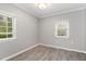 This bedroom features gray walls, wood floors, trim detail and two windows at 7212 Rabbit Run, Wake Forest, NC 27587