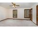 Bedroom with two windows, neutral carpet, ceiling fan and wood trim at 7212 Rabbit Run, Wake Forest, NC 27587