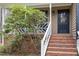 Inviting front porch with brick steps and white railings, framed by a lush green tree at 7212 Rabbit Run, Wake Forest, NC 27587