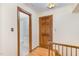 This hallway features wood floors, trim detail, an open bathroom and a wooden door at 7212 Rabbit Run, Wake Forest, NC 27587