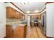 Well-lit kitchen with wood cabinets, granite countertops, stainless steel appliances, and hardwood floors at 7212 Rabbit Run, Wake Forest, NC 27587