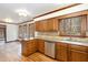 Kitchen featuring wood cabinets, granite countertops, stainless steel dishwasher, and hardwood floors at 7212 Rabbit Run, Wake Forest, NC 27587