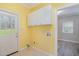 This laundry room features yellow walls, cabinets, tile floors and room for a washer and dryer at 7212 Rabbit Run, Wake Forest, NC 27587