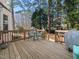 View of wooden back deck with table, chairs, and grill, with a yard and trees in the background at 7301 Turtleneck Ct, Raleigh, NC 27616