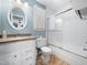 Clean bathroom featuring white subway tile in the shower, oval mirror, and bright window at 7301 Turtleneck Ct, Raleigh, NC 27616
