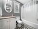 Well-lit bathroom featuring an oval mirror and shower tub combination at 7301 Turtleneck Ct, Raleigh, NC 27616