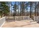 Spacious wooden deck with white railings, providing a peaceful retreat with views of the surrounding wooded landscape at 73214 Burrington, Chapel Hill, NC 27517