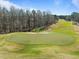 Aerial view of the golf course with a vibrant green, sand trap, and trees at 73214 Burrington, Chapel Hill, NC 27517
