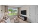 Bright living room featuring a couch, entertainment center, and a large window with backyard views at 7750 Michelle Rd, Rocky Mount, NC 27803