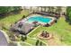Aerial view of community amenities, including a pool and playground, next to the clubhouse, surrounded by lush green spaces at 825 Golden Plum Ln, Zebulon, NC 27597