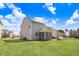 Backyard view of home, screened-in porch, spacious yard, and blue skies at 825 Golden Plum Ln, Zebulon, NC 27597