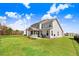 Backyard view with spacious yard, trees, screened-in porch, and blue skies at 825 Golden Plum Ln, Zebulon, NC 27597