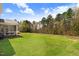Expansive backyard featuring a lush lawn, screened in porch, and a backdrop of mature trees for ultimate privacy at 825 Golden Plum Ln, Zebulon, NC 27597