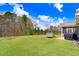 Spacious backyard featuring lush green lawn, trampoline, and access to a screened-in porch at 825 Golden Plum Ln, Zebulon, NC 27597