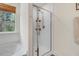 Bright bathroom featuring tiled walk-in shower, window with wood blind, and white walls at 825 Golden Plum Ln, Zebulon, NC 27597