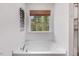 Bright bathroom featuring a soaking tub with a window view and a shower at 825 Golden Plum Ln, Zebulon, NC 27597
