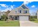 Beautiful two-story home with stone accents, a well-kept lawn, and inviting front porch at 825 Golden Plum Ln, Zebulon, NC 27597