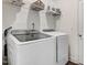 Functional laundry room featuring modern washer and dryer units with overhead shelving at 825 Golden Plum Ln, Zebulon, NC 27597