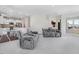 Bright living room featuring gray sofas and views into kitchen at 825 Golden Plum Ln, Zebulon, NC 27597