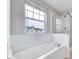Bathroom features an over-sized tub near a large window and a glass shower at 8641 Neuse Club Ln # 110, Raleigh, NC 27616
