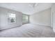 Large carpeted bedroom with two windows and a ceiling fan at 8641 Neuse Club Ln # 110, Raleigh, NC 27616