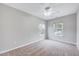 Neutral-toned bedroom featuring plush carpet flooring, a ceiling fan, and natural light from two windows at 8641 Neuse Club Ln # 110, Raleigh, NC 27616