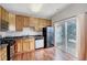 Well-lit kitchen with wood cabinets, black appliances, and sliding glass doors to the backyard at 8641 Neuse Club Ln # 110, Raleigh, NC 27616