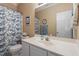 Bright bathroom featuring a sink, toilet, mirror, and a shower with a patterned curtain at 8701 Neuse Village Ct, Raleigh, NC 27616