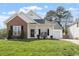 Charming home with a brick accent, covered front porch, and well-maintained lawn at 8701 Neuse Village Ct, Raleigh, NC 27616