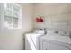 Functional laundry room featuring a washer, dryer, and storage shelves at 8701 Neuse Village Ct, Raleigh, NC 27616