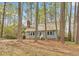 Quaint blue home nestled among tall trees, offering a serene and private setting at 1010 Flanders St, Garner, NC 27529