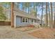Charming blue home with a brick chimney and a landscaped front yard surrounded by mature trees at 1010 Flanders St, Garner, NC 27529