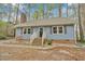 Charming blue home with a brick accent, featuring a welcoming front entrance and manicured landscaping at 1010 Flanders St, Garner, NC 27529