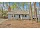 Lovely blue home with a cozy entrance and well-maintained landscaping surrounded by mature trees at 1010 Flanders St, Garner, NC 27529
