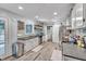 Well-lit kitchen features modern stainless steel appliances, stylish white cabinets, and wood grain vinyl floors at 1010 Flanders St, Garner, NC 27529