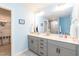 Bathroom featuring double sink vanity, large mirror, and walk-in closet nearby at 1012 Catch Fly Ln, Durham, NC 27713
