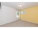 Empty bedroom features two windows, neutral carpet, and a yellow accent wall at 1012 Catch Fly Ln, Durham, NC 27713