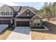 Lovely townhome featuring a stone facade, a convenient two-car garage, and colorful front garden at 1012 Catch Fly Ln, Durham, NC 27713