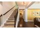 Inviting foyer features a staircase, hardwood floors, and a stylish light fixture, creating a warm and welcoming entrance at 1012 Catch Fly Ln, Durham, NC 27713
