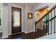 Charming foyer with decorative door, dark hardwood flooring, and staircase with iron spindles leading to the upper level at 1012 Catch Fly Ln, Durham, NC 27713