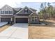 Charming townhome with stone and gray shingle exterior, a two-car garage, and manicured landscaping at 1012 Catch Fly Ln, Durham, NC 27713