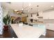 Bright and airy kitchen with white cabinetry, modern lighting, and a large center island with seating at 1012 Catch Fly Ln, Durham, NC 27713