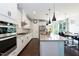 Beautiful kitchen with stainless steel appliances, granite counters, white cabinetry, and hardwood floors, ideal for cooking at 1012 Catch Fly Ln, Durham, NC 27713