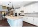 Modern kitchen with white cabinets, granite countertops, stainless steel appliances, and hardwood floors for a sleek look at 1012 Catch Fly Ln, Durham, NC 27713