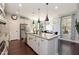 Bright and open kitchen featuring a large island, stainless steel appliances, hardwood floors, and stylish pendant lighting at 1012 Catch Fly Ln, Durham, NC 27713