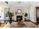 Bright living room with a fireplace, tall windows, hardwood floors, and an open layout, perfect for entertaining at 1012 Catch Fly Ln, Durham, NC 27713
