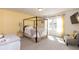 Bright primary bedroom features a canopy bed, and a large window with natural light at 1012 Catch Fly Ln, Durham, NC 27713